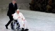 Pope Francis enters the Vatican’s Paul VI Hall in a wheelchair on May 5, 2022.