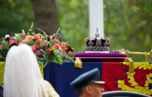 The Imperial State Crown, Sceptre, and wreath of symbolic flowers adorn the coffin of Her Late Majesty Queen Elizabeth II on the gun carriage for the funeral procession, Sept. 19, 2022. Credit: Kelly Chow/Shutterstock